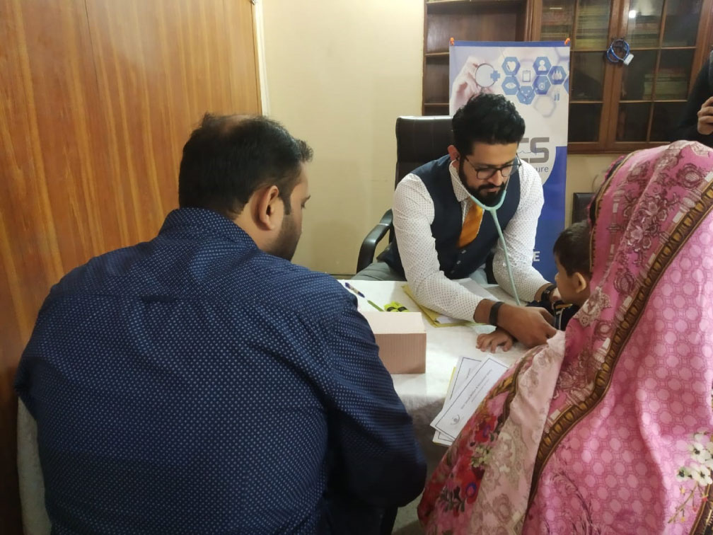 Clinician examining a child at the Noor Zainab camp